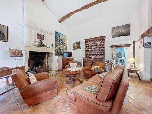 a living room with leather furniture and a fireplace at Holiday Home Petichaud by Interhome in Saint-Sulpice-dʼArnoult
