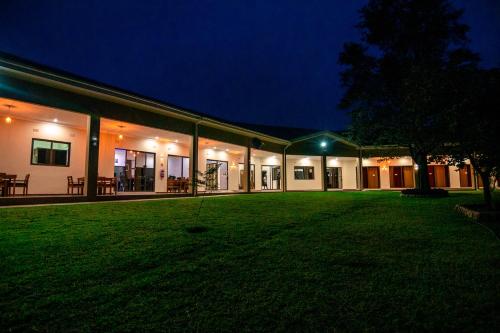 a building with a grassy yard in front of it at night at Luxe Countryside Convention Center in Livingstone