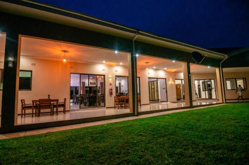 a house with a green lawn in front of it at Luxe Countryside Convention Center in Livingstone