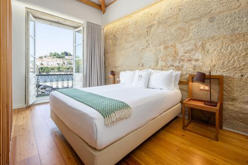 a bedroom with a large white bed and a window at Porta Nobre Boutique Hotel by Aspasios in Porto