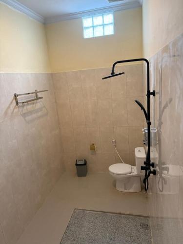 a bathroom with a toilet and a shower at D'vayana Nusa Hotel in Nusa Penida