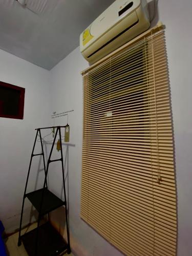 a room with a large window with blinds and a ladder at Neo Robiu & Ijen Tour in Banyuwangi
