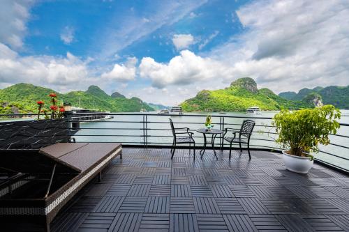 a balcony with a table and chairs on the water at Venus Cruises Halong Bay in Ha Long