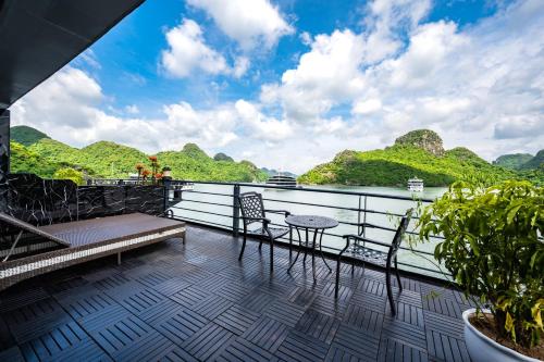 a balcony with a table and chairs on a cruise ship at Venus Cruises Halong Bay in Ha Long