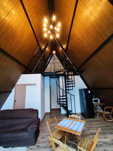a room with a roof with a table and chairs at ESB Chalés in Poços de Caldas