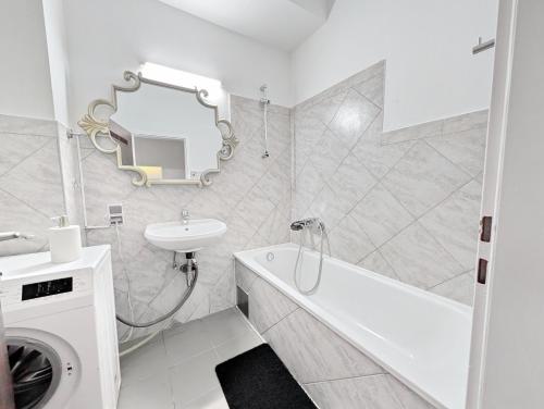 Lovely Rooms in Märzstraße Area MZ49 في فيينا: حمام أبيض مع حوض وحوض ومرآة