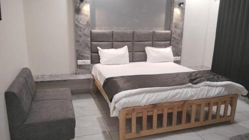 a bedroom with a large bed and a couch at Hotel riseinn in Jāmb
