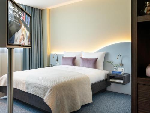 a bedroom with a bed and a flat screen tv at Numa Munich Viktoria in Munich
