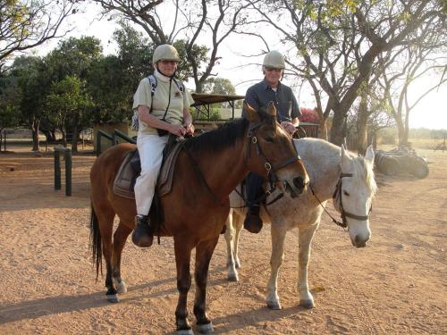 Dos hombres montan a caballo en un campo en Bushtime at Mabula, en Bela-Bela