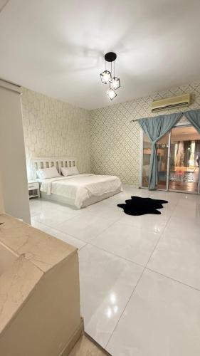 a large bedroom with a bed and a black dog laying on the floor at درة العروس لونق بيش مسبح in Durat  Alarous