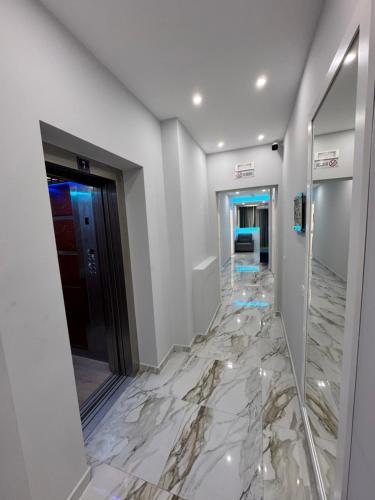 a hallway with a marble floor and a mirror at Suite Rana Hedhun in Shëngjin