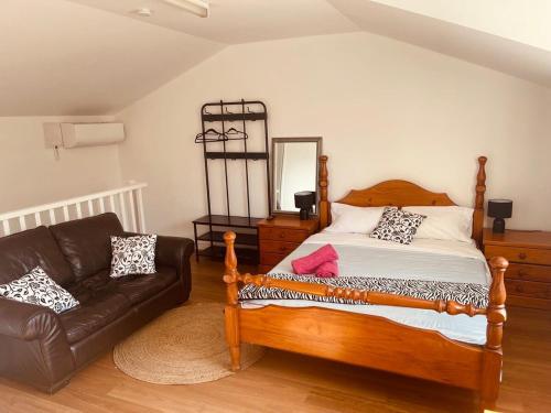 - une chambre avec un lit et un canapé en cuir dans l'établissement Love Cottage, à Glenwood