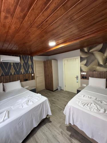 a bedroom with two beds and a wooden ceiling at Nook Boutique in Istanbul