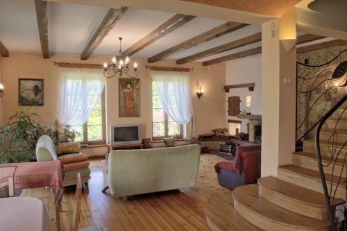 a living room filled with furniture and a staircase at Pensjonacik Ogrody in Pierzchno