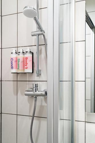 a shower with a shower head in a bathroom at Numa Munich Viktoria in Munich