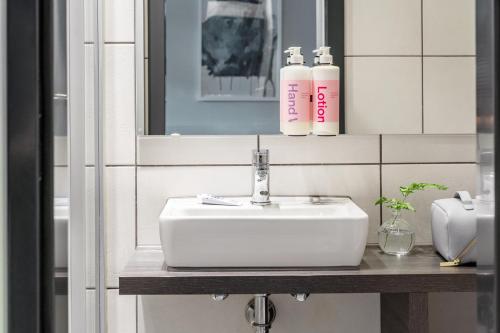 a bathroom with a white sink and a mirror at Numa Munich Viktoria in Munich