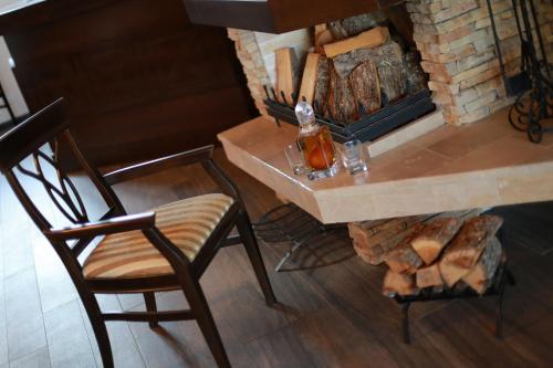 a room with a fireplace and a table and a chair at Villa od Alula in Vevčani