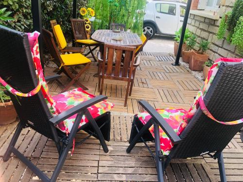 - un ensemble de chaises assises sur une terrasse avec une table dans l'établissement Votre séjour à Sanary DANS BAS DE VILLA avec 1 terrasse végétalisée et abritée exposition Est Sud Ouest à 400m du Centre ville en zone piétonne où tout peut se faire à pied, à Sanary-sur-Mer