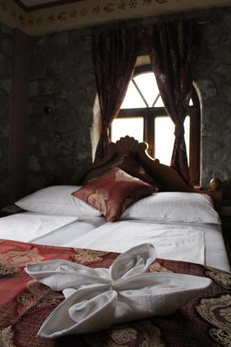 a bedroom with a bed with white sheets and a window at Divan in Plav