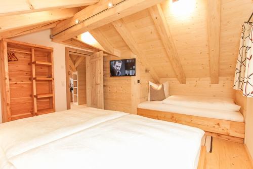 ザールフェルデン・アム・シュタイナーネン・メアーにあるChalet Die Mühleの木製の部屋にベッド2台が備わるベッドルーム1室