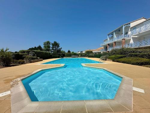 ein großer blauer Swimmingpool vor einem Gebäude in der Unterkunft Apartment L'Orée du Golf-2 by Interhome in Pornic