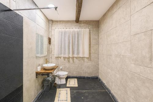 a bathroom with a toilet and a sink at Bellevue Beam House in Covasna
