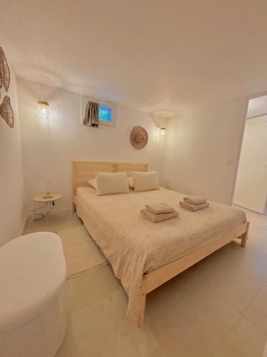 Appartement Cozy T2 proche de la mer في سانت أي جولف: غرفة نوم بها سرير عليه منشفتان