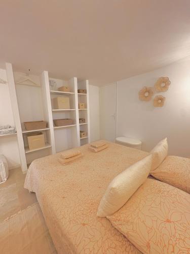 Appartement Cozy T2 proche de la mer في سانت أي جولف: غرفة نوم فيها سريرين ورفوف