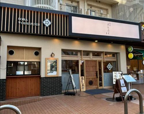a restaurant with a sign on the side of a building at Costa Beach, 8min the beach, 4min Enoshima Station, free Wi-Fi in Kamakura