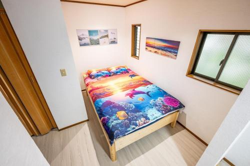 a small bed in a room with a window at Costa Beach, 8min the beach, 4min Enoshima Station, free Wi-Fi in Kamakura