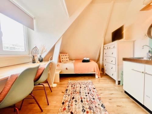 une petite chambre mansardée avec un lit et un tapis dans l'établissement Odyssee, à Zandvoort