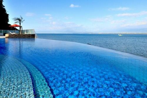 a large swimming pool with a view of the ocean at Costa Beach, 8min the beach, 4min Enoshima Station, free Wi-Fi in Kamakura