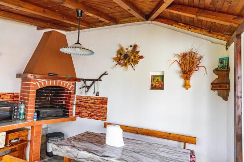 a kitchen with a brick fireplace and a table at Cozy Villa Retreat in Cigov Chark in Tsigov Chark