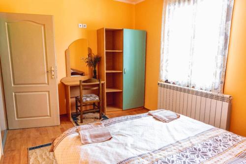a bedroom with a bed and a desk and a window at Cozy Villa Retreat in Cigov Chark in Tsigov Chark