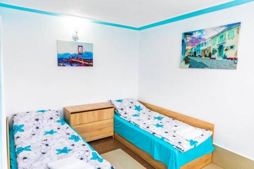 a bedroom with two beds and a picture on the wall at Cozy Villa Retreat in Cigov Chark in Tsigov Chark
