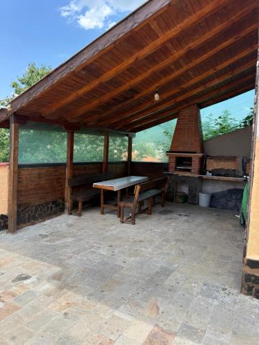 a pavilion with a picnic table and an outdoor oven at Къща за гости Леон in Belogradchik