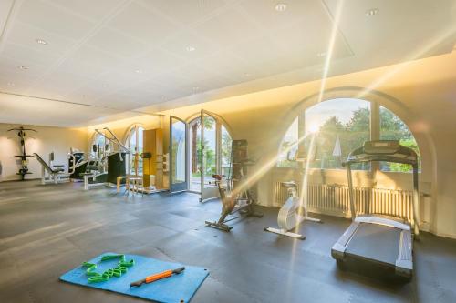 a gym with treadmills and exercise equipment in a room at Bellavista Swiss Quality Hotel in Vira