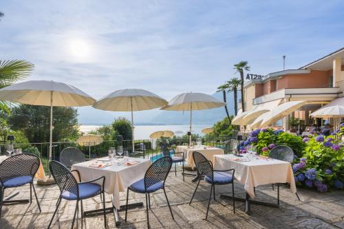 a restaurant with tables and chairs with umbrellas at Bellavista Swiss Quality Hotel in Vira