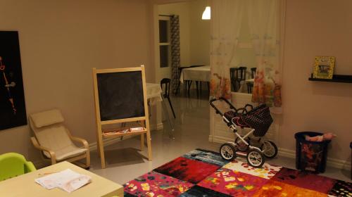 a living room with a baby stroller and a classroom at Hotell Vindelngallerian in Vindeln
