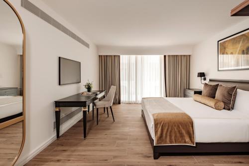 a hotel room with a bed and a desk at 1926 Les Bains Private Spa Suites in Sliema