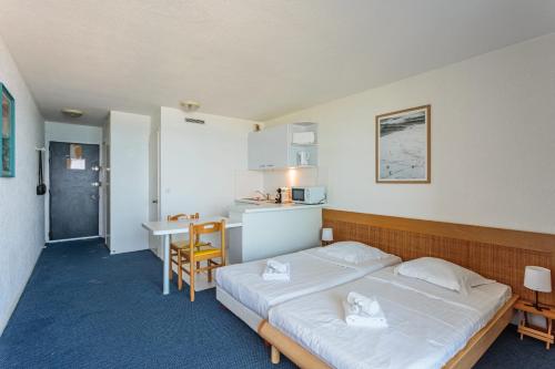ein Schlafzimmer mit einem großen Bett und einem Schreibtisch in der Unterkunft Studio Helder vue mer - Welkeys in Biarritz