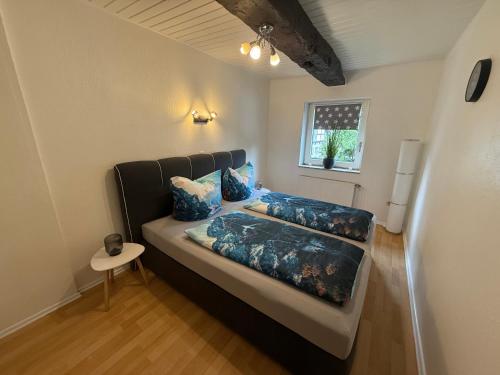 a bed with blue pillows on it in a room at Mühlenzauber Hameln in Hessisch Oldendorf