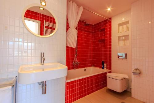 a bathroom with a sink and a toilet and red tiles at Panoramic views and a swimming pool near the airport in Gran Alacant