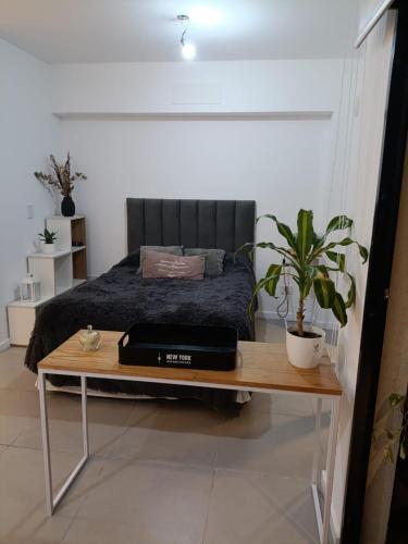 a bedroom with a bed and a table with a laptop on it at Depto H in Buenos Aires