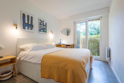 a white bedroom with a bed and a window at Le Mérignac Cozy Corner - T3 & Terrasse in Mérignac