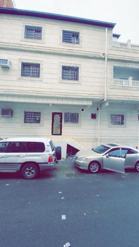 two cars parked in a parking lot in front of a building at استديو مصيف الراحه in Taif