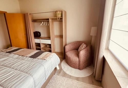 a bedroom with a bed and a chair in it at Charmante woning in de Vlaamse Ardennen in Sint-Lievens-Houtem