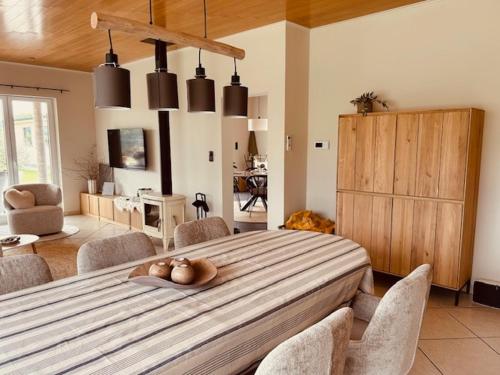 a dining room with a large wooden table with chairs at Charmante woning in de Vlaamse Ardennen in Sint-Lievens-Houtem