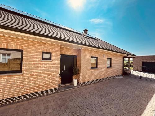 a brick building with a door and a courtyard at Charmante woning in de Vlaamse Ardennen in Sint-Lievens-Houtem