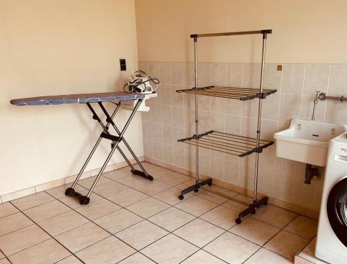 a laundry room with a sink and a shelf at Charmante woning in de Vlaamse Ardennen in Sint-Lievens-Houtem
